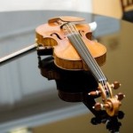 Violin rests atop the grand piano before the wedding ceremony beings.