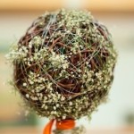 Baby's Breath wrapped around a round bridal bouquet of vine strands.