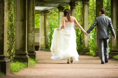 Newly-Married Bride and Groom Walk Hand in Hand