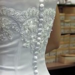 Bride shops for shoes to match her white satin and lace wedding gown.
