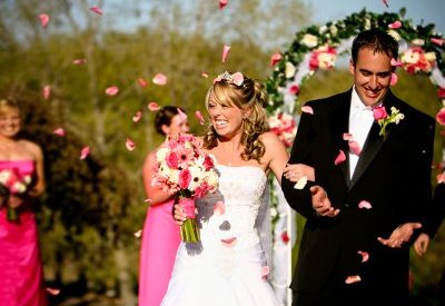 Bride and groom are showered with rose petals from their guests following the wedding ceremony.