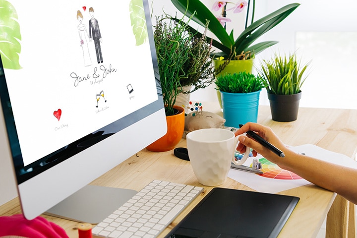 Web designer styling a wedding website at at her desk