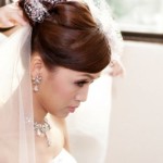 Bride gets the final touches added to her wedding day hairstyle, including the veil.