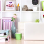 Wedding planning workspace with colorful binders and shelving.