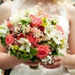 Bride carries a pink, green and white floral bouquet after the wedding ceremony.