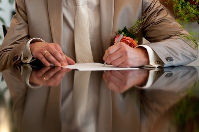 Groom signs marriage licence on the wedding day.