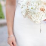 Bride carries beautiful ivory and pale peach rose bouquet after the wedding ceremony.