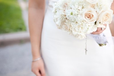 Bride carries beautiful ivory and pale peach rose bouquet after the wedding ceremony.