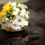 Bride's yellow, white and green bouquet atop the limousine.