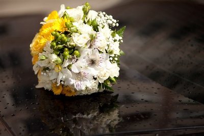 Bride's yellow, white and green bouquet atop the limousine.