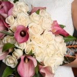 Bride carries her bouquet of ivory roses and light mauve calla lilies.