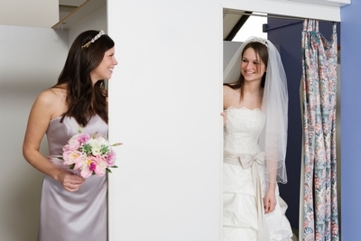 Bride and her maid of honor attend a final dress fitting.